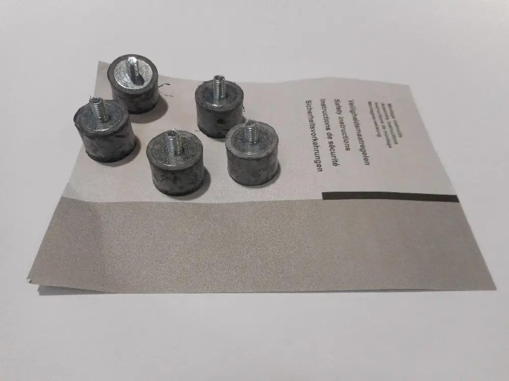 Sechs Metallunterlegscheiben auf einem Papier mit Anweisungen, das einen Teil der Produktinformationen von Remeha enthält.